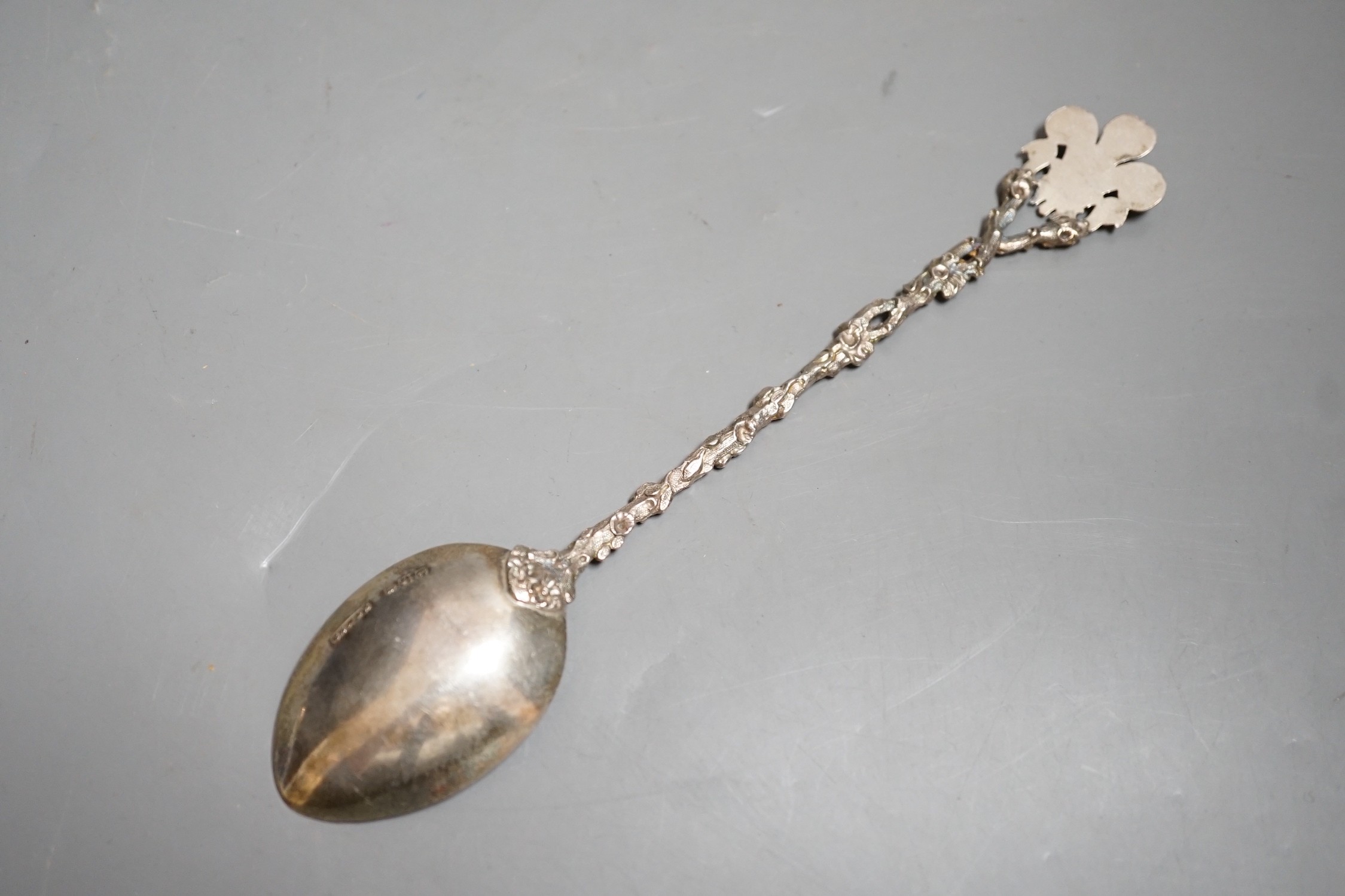 A late Victorian silver and enamelled spoon, with rustic stem and Prince of Wales feathers terminal, the bowl engraved with the Royal Coat of Arms, Saunders & Shepherd, London, 1896, 20.2cm, gross 43 grams.